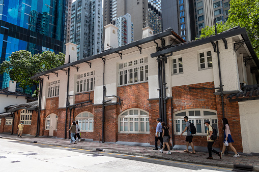 Hong Kong - July 21, 2022 : Pedestrians walk past the Oil Street Art Space in Causeway Bay, Hong Kong. The complex served as the Royal Hong Kong Yacht Club headquarters and clubhouse until 1938.
