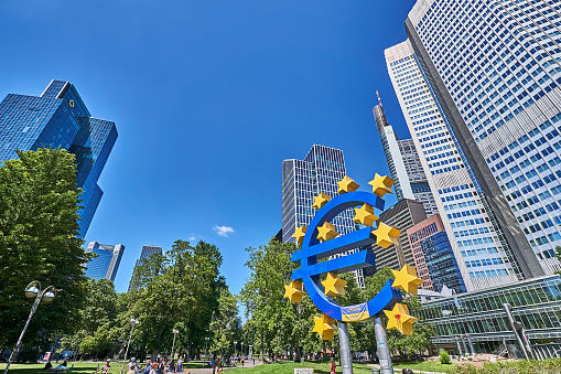 Frankfurt am Main, Germany - July 08, 2022:  Crowd at the euro symbol in front of the banking district in Frankfurt.