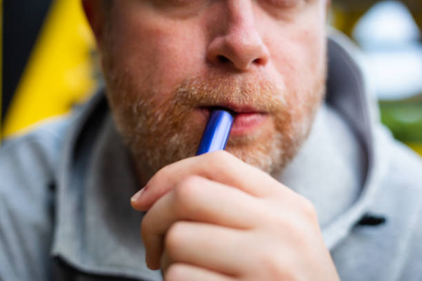 istock Mid adult male vaping using disposable vape outdoors 1410075421