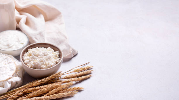istock Shavuot background with dairy products and wheat on light gray background, web banner 1410076666