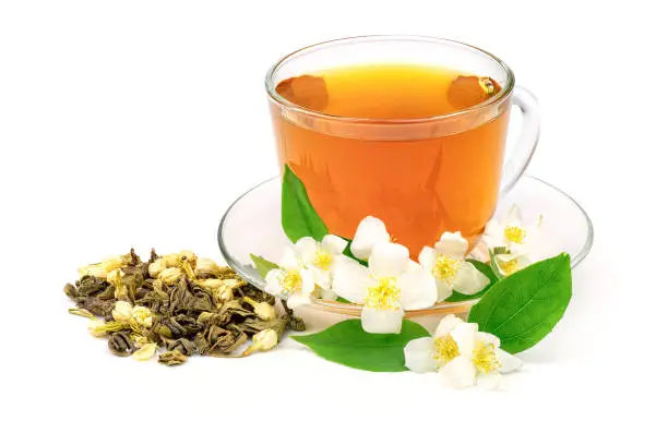 Photo of Cup of green tea with jasmine flowers isolated on white background.
