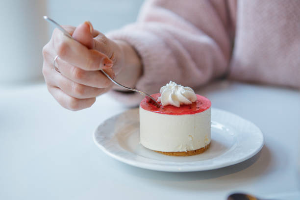 istock Red and white cake being cut with fork in female hand. 1410080938