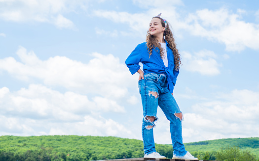 Happy kid wear checkered shirt. Lifestyle and People Concept. kid spring and fall fashion. casual hipster look. childhood happiness. teen girl on sky backdrop. having a party fun. Fashion and beauty.