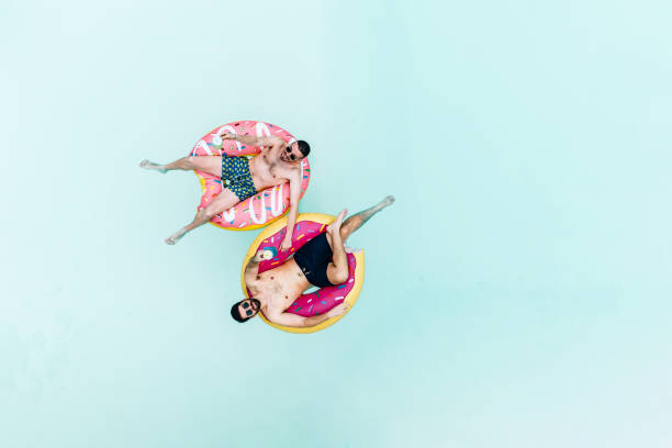 Two friends are floating on inflatables in the swimming pool