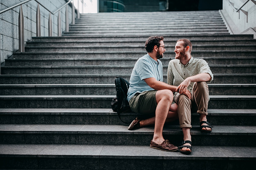 Gay couple bonding on a city stairs