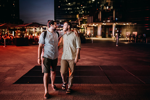 Gay couple on city break, exploring magical streets of downtown district