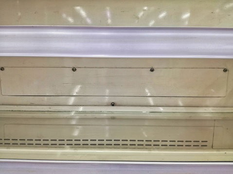 Empty shelf on grocery store after being rushed by shoppers. Rack supermarket consumer goods indoor object. Background template copy space.