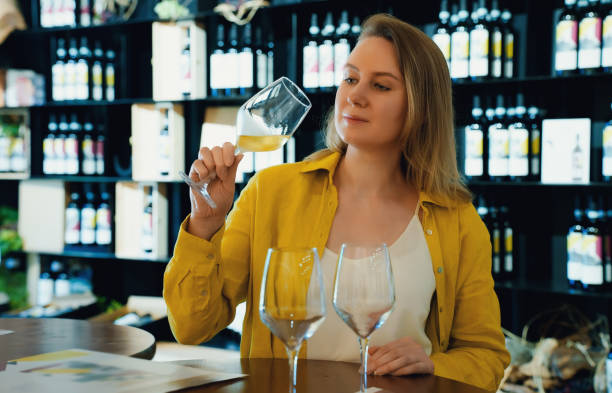 Woman is tasting white wine at a winery. stock photo