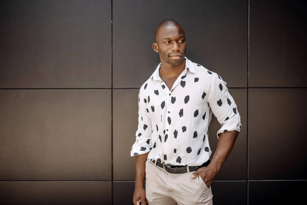 Portrait of young handsome man against black wall