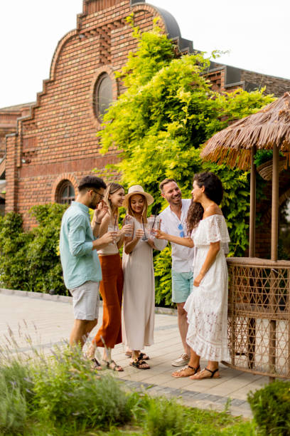 istock Group of young people cheering and having fun outdoors with drinks 1410092980