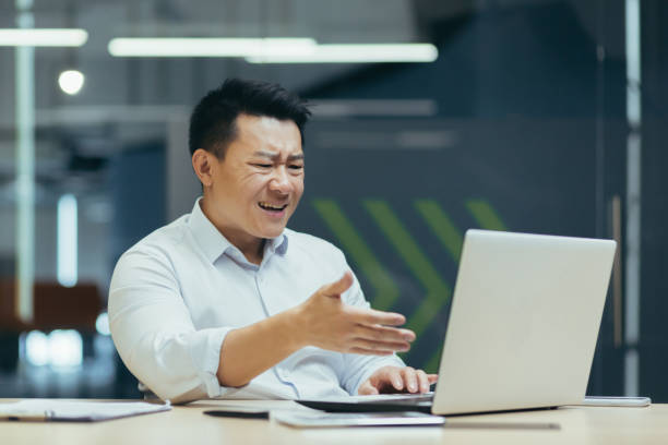 istock Frustrated and angry asian businessman talking on video call 1410097199