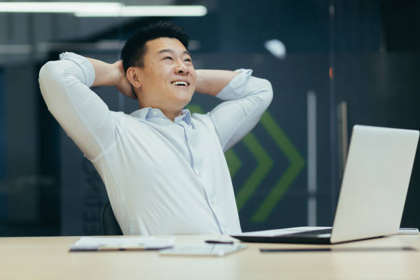 istock Dreamy successful Asian businessman working in office, smiling, 1410097262