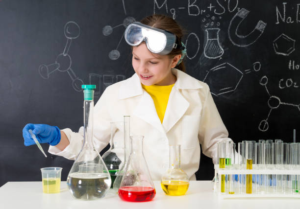 schoolgirl in white gown doing experiments with liquids