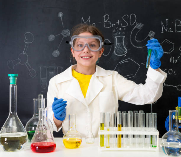 istock schoolgirl in white gown doing experiments with liquids 1410097376