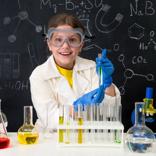 istock schoolgirl in white gown doing experiments with liquids 1410097378