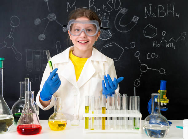 istock schoolgirl in white gown doing experiments with liquids 1410097380