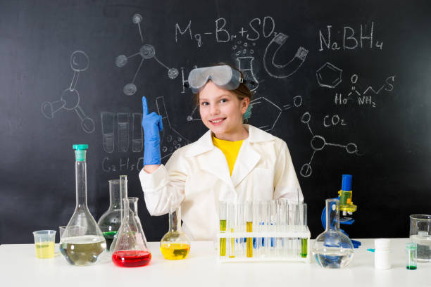 istock schoolgirl in chemistry lab pointing at formula on blackboard 1410097381
