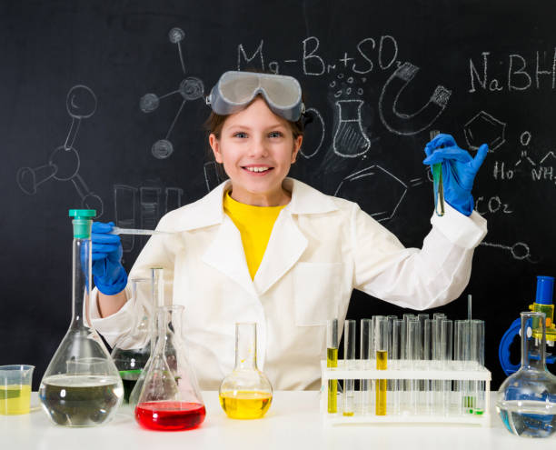 istock schoolgirl in white gown doing experiments with liquids 1410097383
