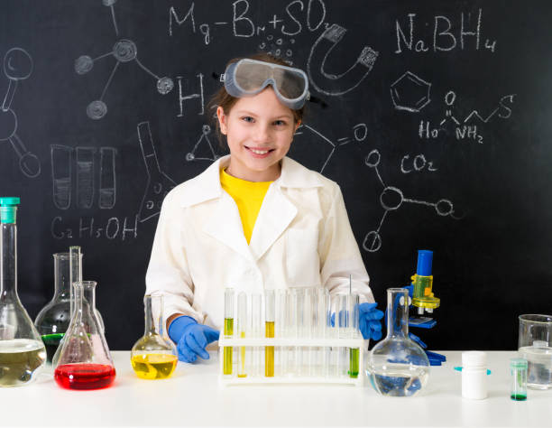 istock schoolgirl in white gown doing experiments with liquids 1410097389