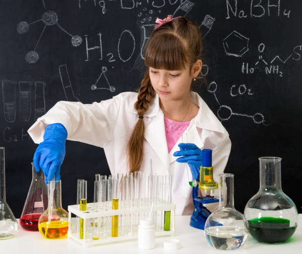 istock little smarl girl in chemistry lab doing an experiment 1410097396