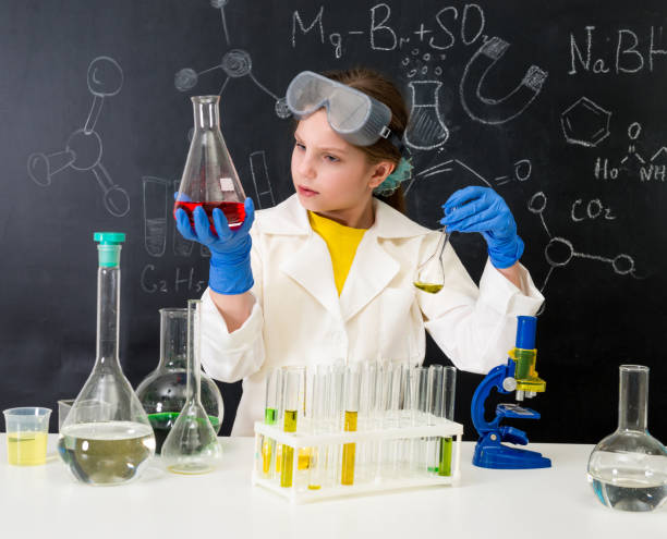 istock schoolgirl in white gown doing experiments with liquids 1410097398