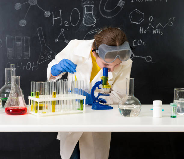 istock schoolgirl in white gown doing experiments with liquids 1410097399