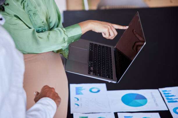 istock Businesspeople using a laptop while going over paperwork during an office meeting 1410098052