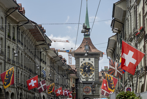 Bern Switzerland , 22 June 2022 : Tourists in old Kramgasse street with Samsonbrunnen or Samson fountain and Zytglogge clock tower in Bern old town Switzerland