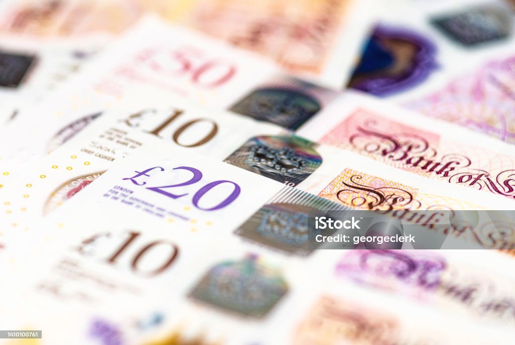 Collectoin of Bank of England notes in a row Macro image of several GBP notes issued by the Bank of England, including £10, £20 and £50 banknotes. British Currency Stock Photo