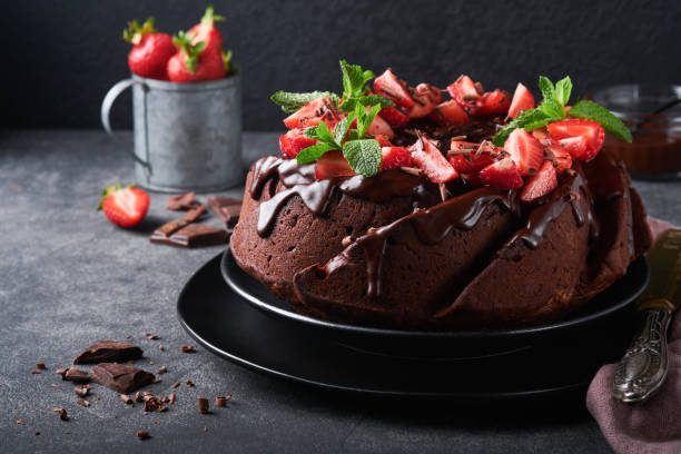 istock Dark Chocolate Bundt Cake with Ganache Icing and strawberry on dark stone or concrete table background. Festive cake. Selective focus 1410100969
