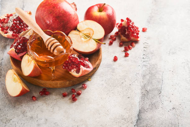 istock Rosh Hashanah. Pomegranate, apples and honey traditional products for celebration on rustic grey background. Jewish Autumn Rosh Hashana celebration. Jewish holiday Rosh Hashana design. Selective focus 1410103791