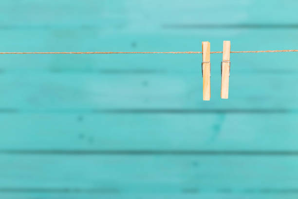 two clothespins on rope over blue wooden background