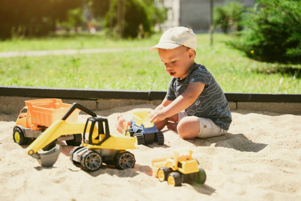istock Child playing in sandbox. Little boy having fun on playground in sandpit. Outdoor creative activities for kids. Summer and childhood concept 1410104472