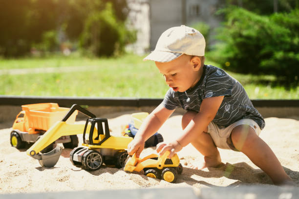 istock Child playing in sandbox. Little boy having fun on playground in sandpit. Outdoor creative activities for kids. Summer and childhood concept 1410104476