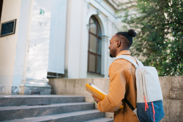 istock Young adult university student entering the educational building 1410104771