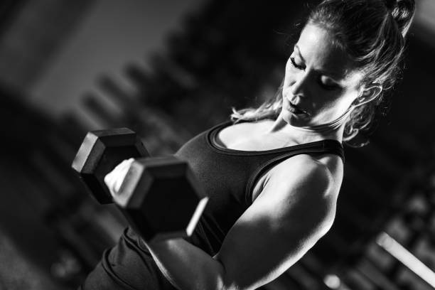 istock Cross training. Young woman exercising with dumbbells 1410105874