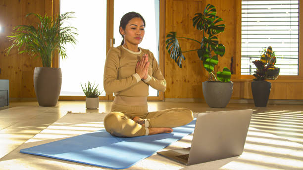 istock CLOSE UP: Asian yoga instructor introducing yoga breathing techniques online 1410107627