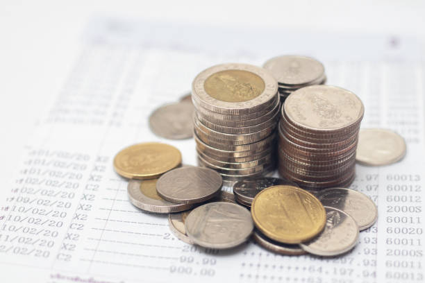 istock Coins are placed on the account book. money saving concept 1410108825