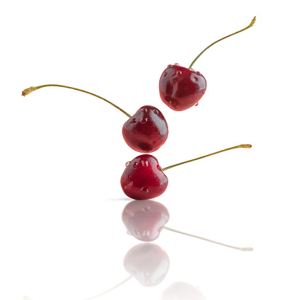 Falling cherry berries isolated on white background. Creative food for design.