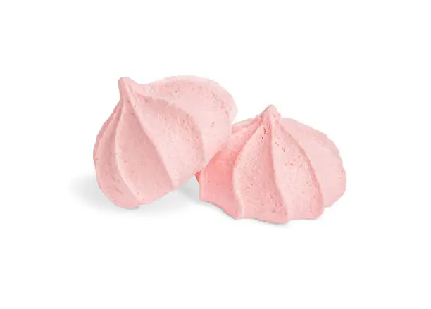 Photo of Two pink meringues isolated on white background.