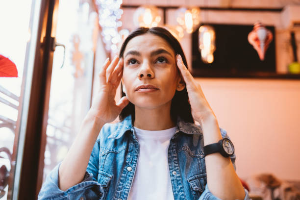 istock Tired young woman holding her temples looks at one point 1410109366