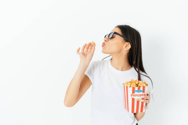 istock Young woman enjoying eating popcorn 1410109450