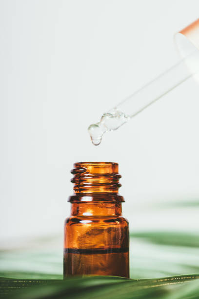 istock Drop of essential oil drips from pipette into bottle 1410109483