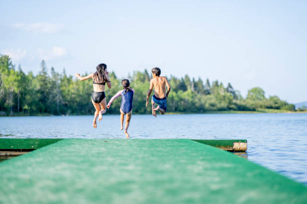children running off a dock - canadian beach imagens e fotografias de stock