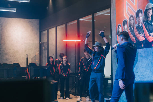 istock winning Asian Esports Team players on stage introduced by game host emcee after grand final videogame on stage. Videogame Championship Arena. Cyber Games Tournament Event 1410113874