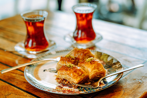 Delicious Turkish baklava and tea on a wooden table top