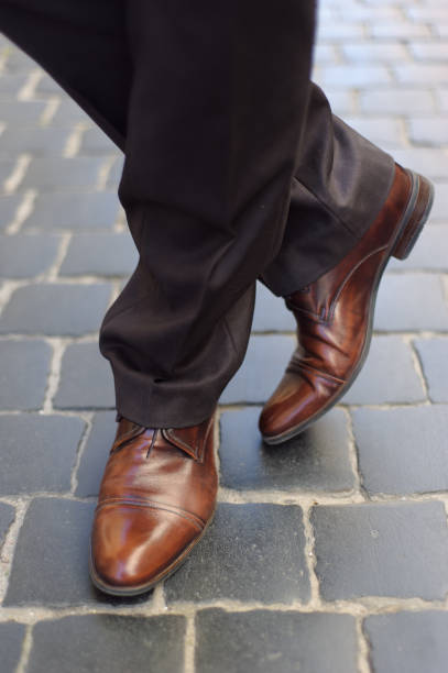 istock Men's feet in shoes on the pavement 1410117845