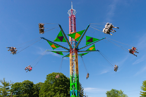 People flying in the air enjoying a fun ride at an amusement park - lifestyle concepts