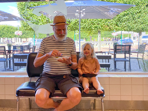 Grandfather with his toddler granddaughter having a break for fish