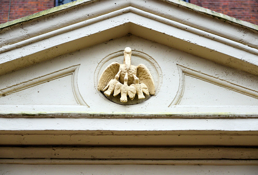 Amsterdam, The Netherlands: Portuguese Synagogue (the Esnoga) - 17th-century Sephardic temple - designed by architect Elias Bouwman and opened in 1675 - detail of the tympanum above the entrance gate - a bleeding pelican who wounds its breast and feeds its three young birds with its own blood is the unusual symbol of the Synagogue,more common in medieval Christian art.